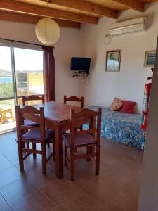 a dining room with a table and chairs and a bed at Chalets du lac in Capilla del Monte +17 photos