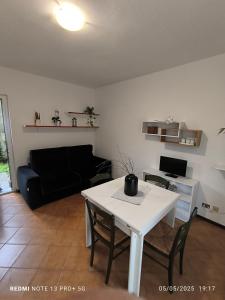 a living room with a white table and a black couch at Dimora Nella Roccia in San Siro
