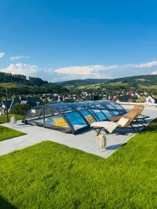 un paio di sedie e una tenda su un campo erboso di Apartament Krynica-Zdrój - Powroźnik - Dom na wzgórzu- House on the hill z basenem a Powrożnik