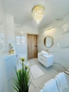 un bagno bianco con lavandino e specchio di Apartament Krynica-Zdrój - Powroźnik - Dom na wzgórzu- House on the hill z basenem a Powrożnik