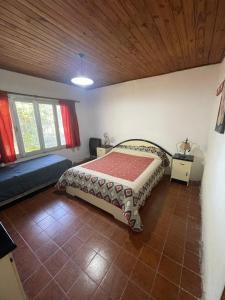 a bedroom with a bed and a couch in a room at Casa de chacra in Veinticinco de Mayo