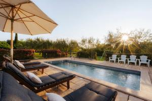 a swimming pool with two couches and an umbrella at Ferienhaus Rovinj mit Pool in Rovinj