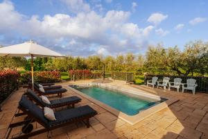 a swimming pool with lounge chairs and an umbrella at Ferienhaus Rovinj mit Pool in Rovinj