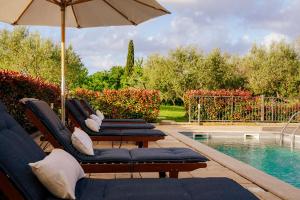 three lounge chairs and an umbrella next to a swimming pool at Ferienhaus Rovinj mit Pool in Rovinj