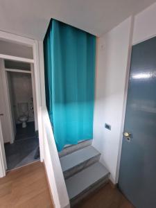 eine Treppe in einem Zimmer mit blauer Wand in der Unterkunft Elegante nel Centro Storico del Monferrato in Casale Monferrato + 21 Fotos