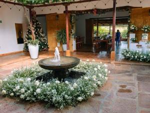 a fountain in the middle of a room with flowers at Santa Sofia Casa Boutique in Barichara