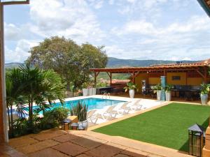 a swimming pool with a lawn next to a house at Santa Sofia Casa Boutique in Barichara