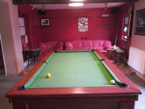 Una sala de estar con una mesa de billar y un sofá. en Lower Lode Inn, en Tewkesbury