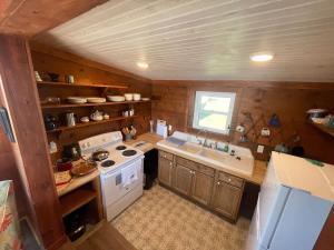 Una pequeña cocina con estufa y fregadero. en Private Cozy Waterfront Cabin, en Sealevel