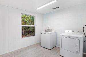 a white laundry room with a washer and a window at The Hideaway Cottage at Palmview Inn of Sanibel in Sanibel +16 photos