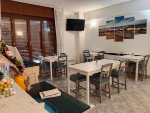 a restaurant with tables and chairs and a television at Casa Glicine in Finale Ligure