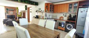 a kitchen and living room with a wooden table and appliances at Къща за гости ,,Ива'' in Bŭlgarevo