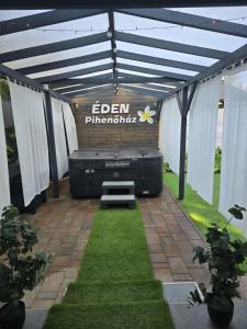 an outdoor pergola with a bed in the middle at Éden Pihenőház in Veresegyház