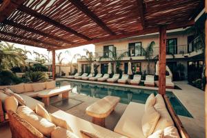 a swimming pool with couches and chairs next to a house at Wakana Alaçatı in Alacati