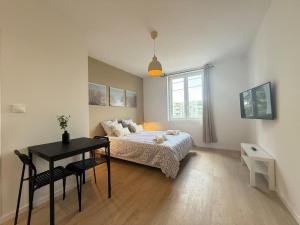a bedroom with a bed and a table and a desk at Studio Mars NEW & Cozy - Parilly Train Station in Vénissieux