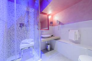 a bathroom with a glass shower and a sink at Hotel Vespasiano in Rome