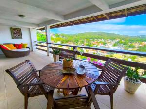 a wooden table and chairs on a balcony at Suites Buzios in Búzios