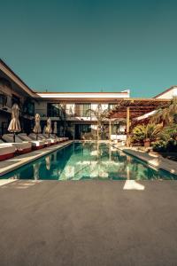a swimming pool with chairs and a building at Wakana Alaçatı in Alacati