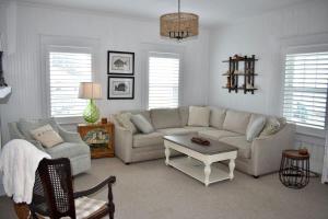 un soggiorno con un divano e un tavolo di Comfortable Down East Waterfront Farmhouse a Sealevel