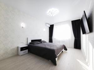 a white bedroom with a bed and a window at Апартаменты Kadorr 59 in Odesa