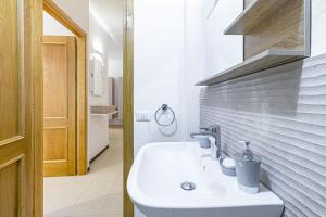 a bathroom with a sink and a brick wall at Nura's - Luna Charme House in Alghero +24 photos