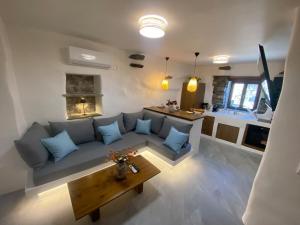 a living room with a couch and a table at Verde Studio Steni, Tinos in Stení