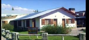 佩里托莫雷诺Aparthotel Koshem的一座白色的房子，前面有一块牌子