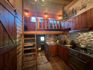 a kitchen with wooden cabinets and a stove top oven at Alyeska Spruce Cabin in Girdwood