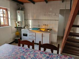 a kitchen with a table and chairs and a stove at Aparthotel Koshem in Perito Moreno