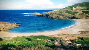 una spiaggia con un gruppo di persone sulla spiaggia di Casa Vacanze TIO a Palmadula Altre 8 foto