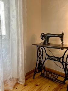 una máquina de coser sentada en una mesa junto a una ventana en The Tailor's House, en Corfu