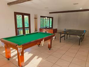 a living room with a pool table and two tables at Suites Buzios in Búzios