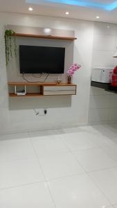 a flat screen tv on a wall in a kitchen at Pôr do sol beach house in Porto Seguro