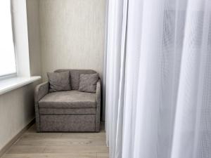 una silla sentada en una esquina junto a una ventana en Апартаменты Kadorr 54, en Odessa 29 fotos más