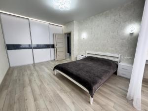 Un dormitorio con una cama y suelo de madera. en Апартаменты Kadorr 54, en Odessa