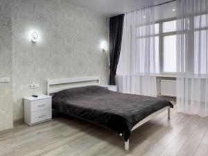 un dormitorio con una cama y una ventana en Апартаменты Kadorr 54, en Odessa