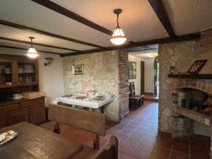 a kitchen and living room with a stone fireplace at Lovačka kuća Draganić in Draganići