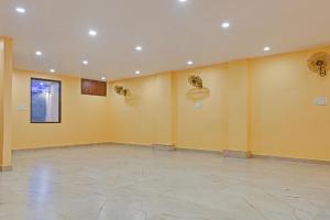 a large empty room with yellow walls and detectors at OYO Townhouse 1123 Kalyanpur Metro in Kaliānpur