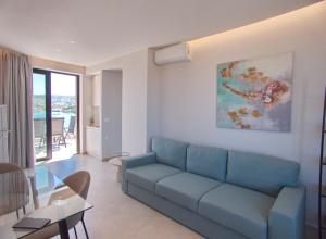 a living room with a blue couch and a table at Bay view in town in Chania