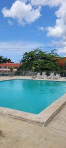 a swimming pool with chairs and blue water at Apartamento en Boca Chica T1 206 in Boca Chica