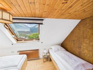 a bedroom with two beds and a window at Ferienhaus zum Klettersteig - Kletterwand, Abstellraum für Ski oder Bikes, Sauna, Kellerbar, in Bürs