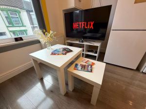 リバプールにあるAnfield Courtyard Retreatのテーブルとテレビのあるリビングルーム