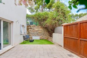 a garden with a stone wall and two chairs at Ciotat t2 in La Ciotat