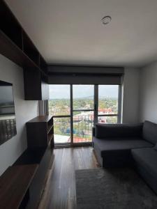 a living room with a couch and a large window at Cozy apartment, all amenities in Mexico City