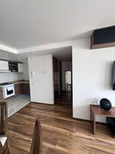 a living room with white walls and wooden floors at Cozy apartment, all amenities in Mexico City