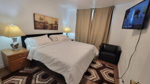 ein Schlafzimmer mit einem Bett und einem Flachbildfernseher in der Unterkunft 4-Bedroom Home by Downtown and Airport in Calgary