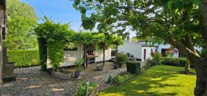 a garden with a white house with a tree at Hof van Lapscheure in Damme