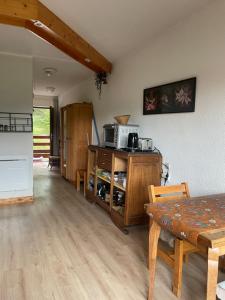 a kitchen with a table and a microwave on a counter at Le ZEN au pied du Grand Veymont en été en hiver in Gresse-en-Vercors