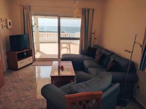 een woonkamer met een bank, een tafel en een televisie bij Bungalow with 2 bedrooms in Costa Calma