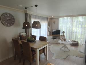 een woonkamer met een tafel en een klok aan de muur bij Urbane Holiday Home in Garderen with Terrace and Garden in Garderen +32 foto's
